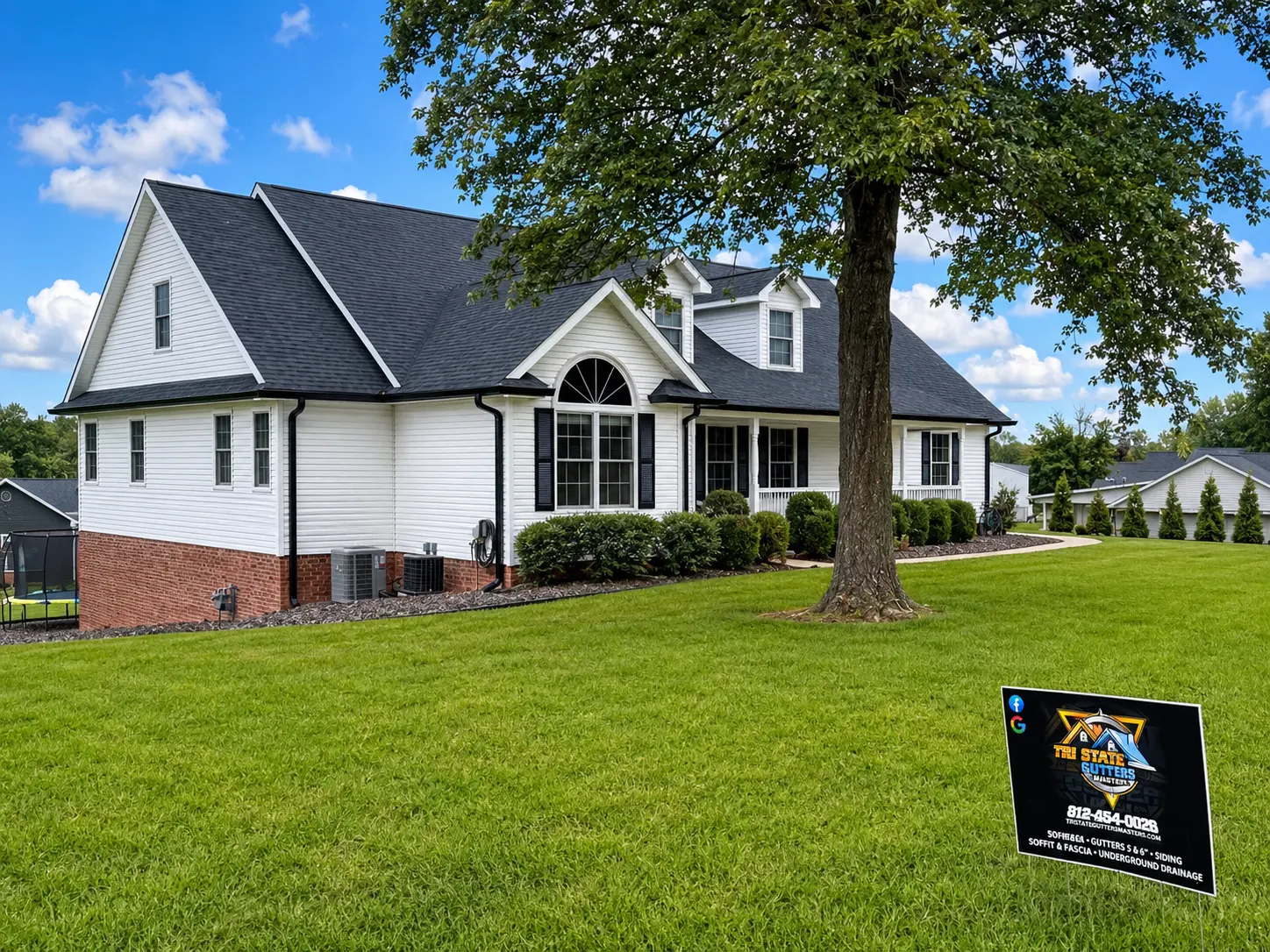 Finished black seamless gutters on a bright residential roofline