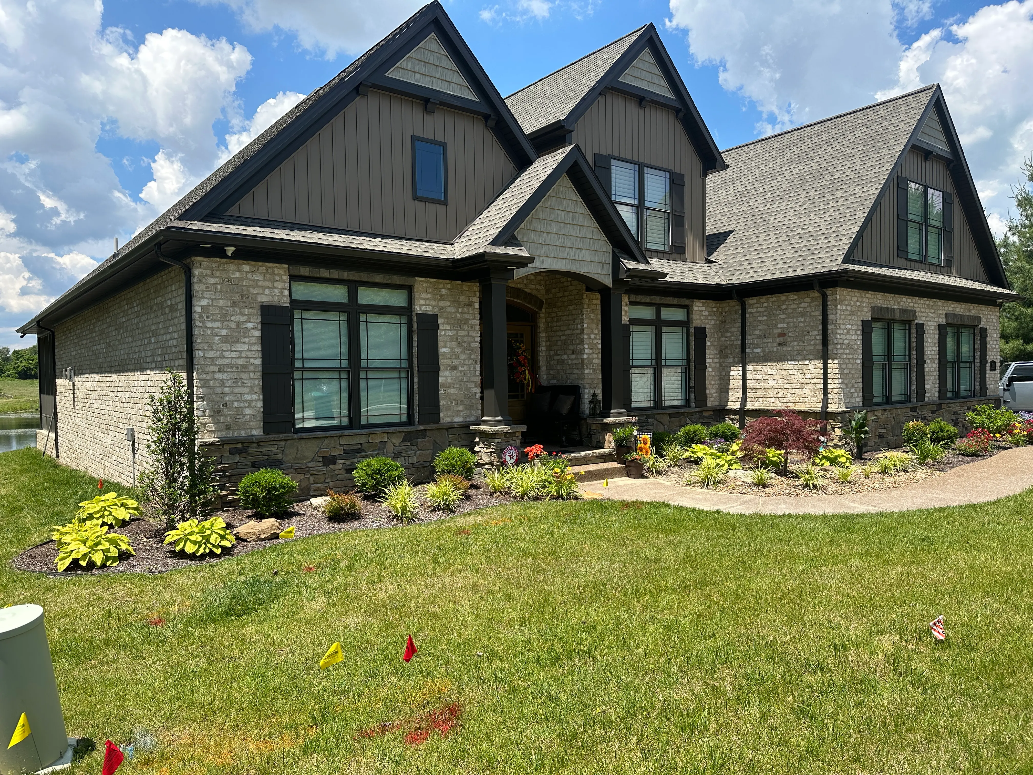New gutters installed on a landscaped brick home