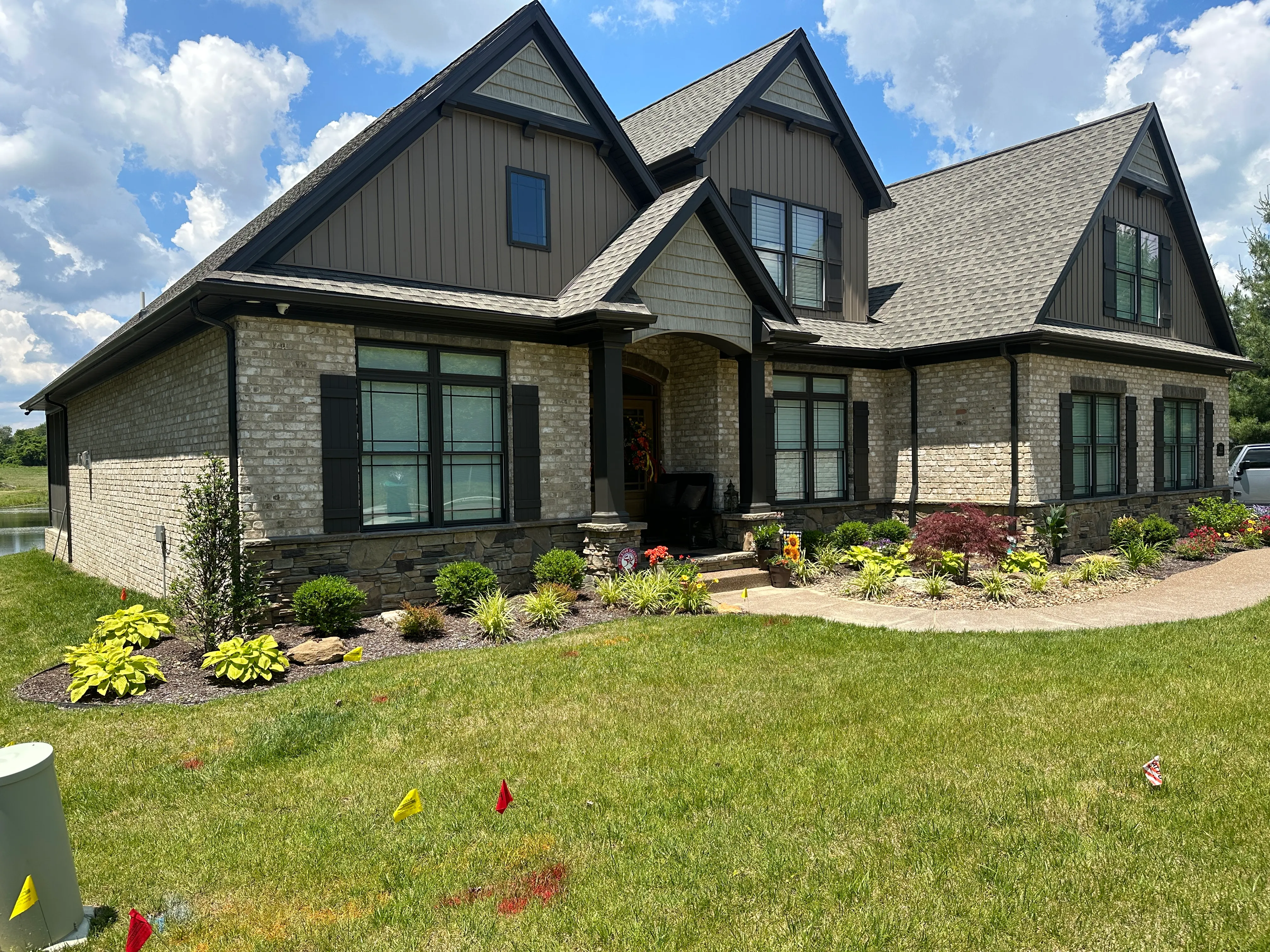 Completed seamless gutter installation on a landscaped brick home