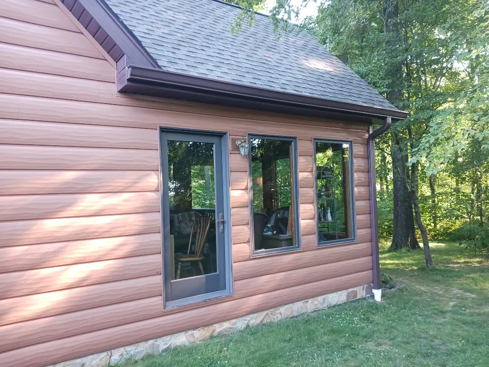 Home exterior front view showing newly installed gray vinyl siding and clean white trim